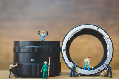 Close-up of figurines repairing wristwatch on table