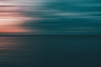 Scenic view of motion blurred sea against sky during sunset