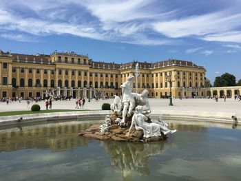 Statue in front of building against cloudy sky schonbrunn palace