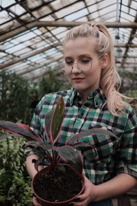 Portrait of smiling woman standing against plants