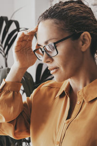 Close-up of young woman looking away against wall