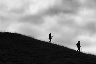 Silhouette people on field against sky