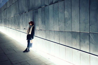 Full length of a young woman standing on tiled floor
