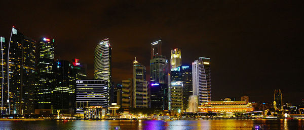 Low angle view of illuminated cityscape against sky at night