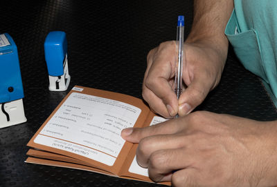 High angle view of man hand on paper