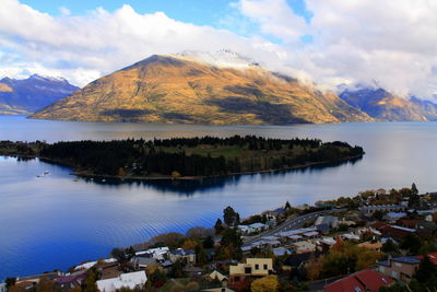 Scenic view of lake by buildings against sky