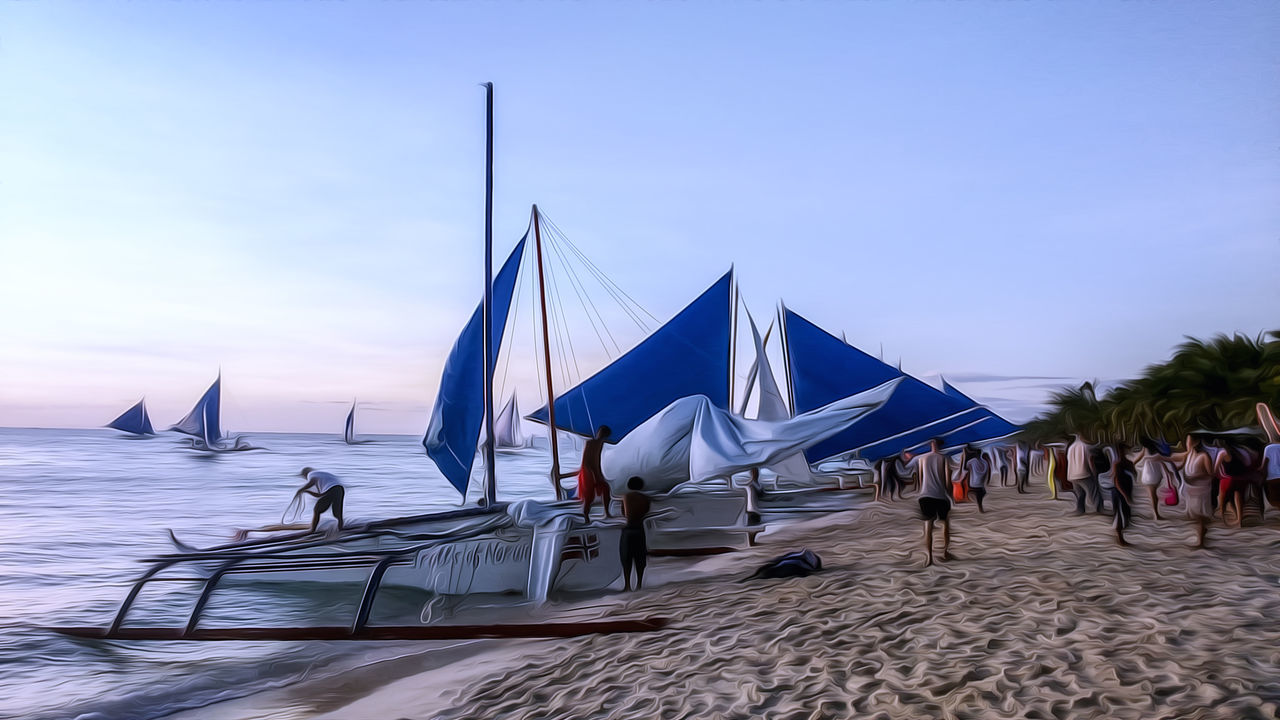 PEOPLE ON BEACH AGAINST SKY