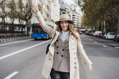 Portrait of smiling young woman standing in city