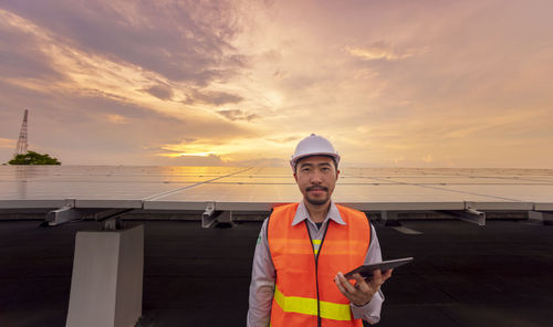 Portrait of man standing against sky during sunset