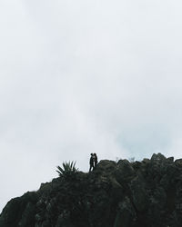 Person on rock against sky