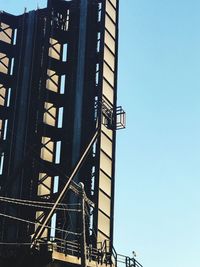 Low angle view of ferris wheel against clear blue sky