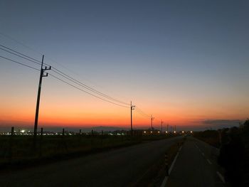 Silhouette road against sky during sunset