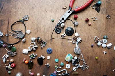 Close-up of beads and pliers on wooden table