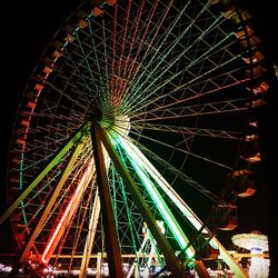 Low angle view of illuminated ferris wheel against sky at night