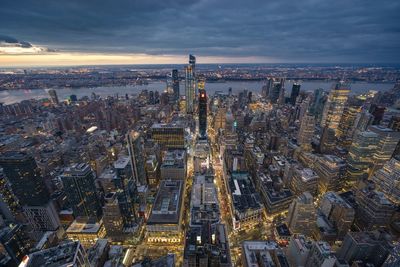 High angle view of city buildings against cloudy sky