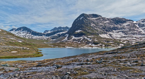 Scenic view of lake and snowcapped mountains against sky