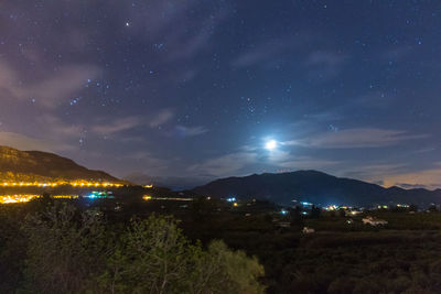 Scenic view of illuminated mountains against sky at night