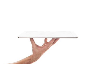Close-up of hand holding paper over white background