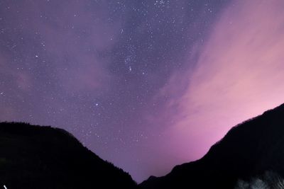 Low angle view of silhouette mountain against sky at night