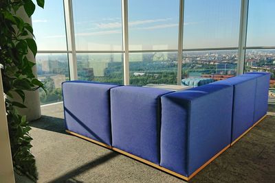Chairs and table against sky seen through glass window