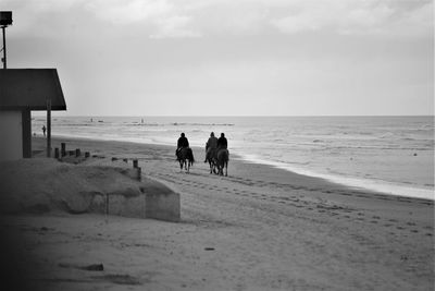 People on beach against sky