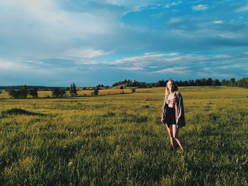 Woman standing on field against sky