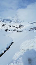 Scenic view of snow covered mountains against sky