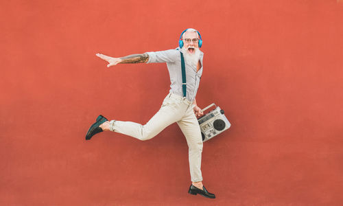 Portrait of man standing against red background