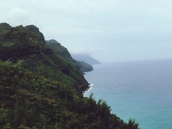 Scenic view of sea by cliff against sky