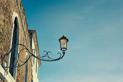 Low angle view of street light against blue sky