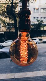 Close-up of illuminated light bulb on street