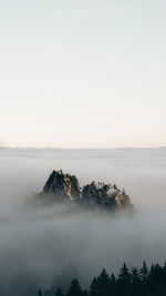 Mountainpeak rises through the clouds