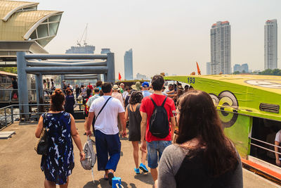 Rear view of people in city against sky