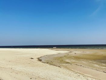 Scenic view of beach against blue sky
