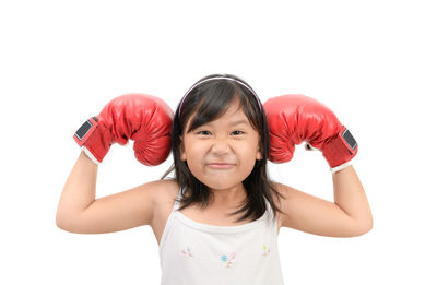 Portrait of girl wearing red boxing gloves against white background