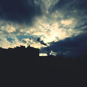 Silhouette of building against cloudy sky