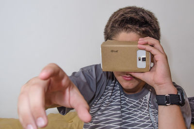 Close-up of boy gesturing while wearing virtual reality simulator