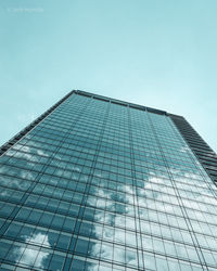 Low angle view of glass building against clear sky