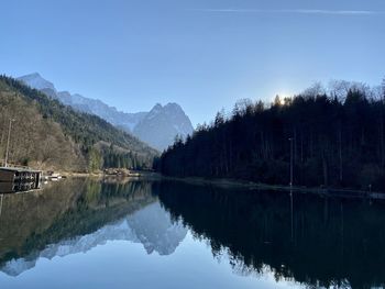 Scenic view of lake by trees against sky