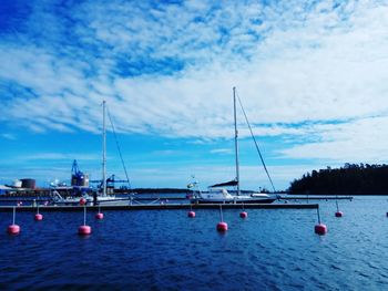 Sailboats in sea against sky