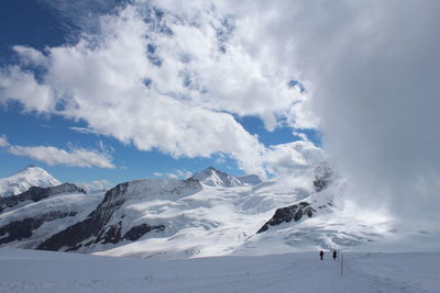 Scenic view of snowcapped mountains against cloudy sky