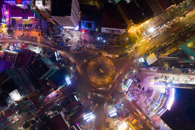 High angle view of illuminated street amidst buildings at night