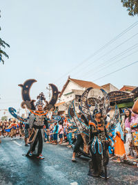 Group of people on street against sky