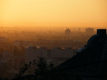 High angle view of silhouette buildings against sky during sunset