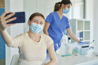 Woman wearing mask talking selfie at hospital