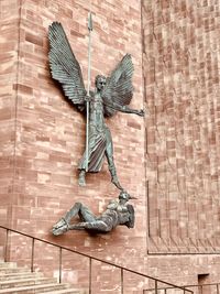 View of a bird flying against brick wall