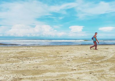 Scenic view of beach against cloudy sky