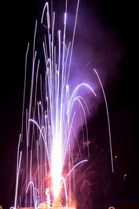 Low angle view of firework display at night