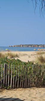 Scenic view of beach against clear blue sky