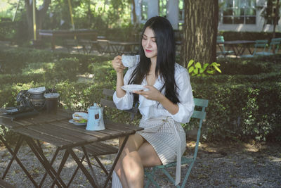 Beautiful woman drinking coffee in garden